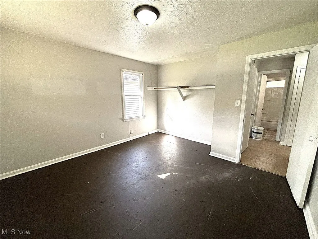 Unfurnished bedroom featuring a textured ceiling and a closet