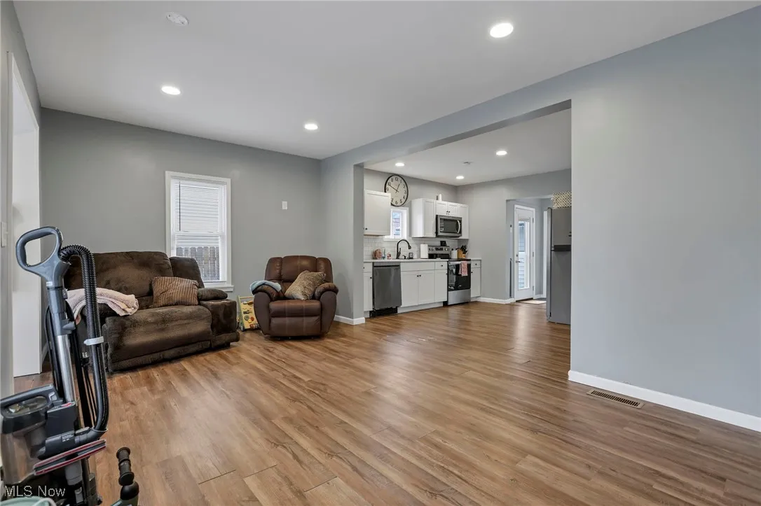 Living room with light wood finished floors and recessed lighting