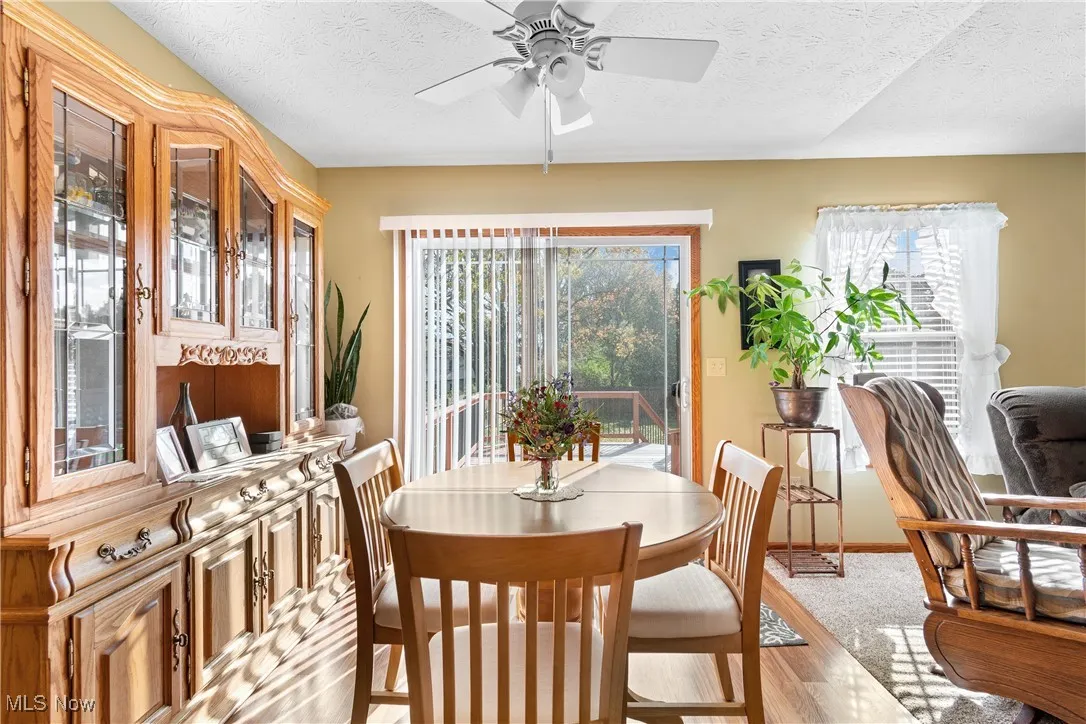 Dining space featuring a textured ceiling, light wood-style flooring, and ceiling fan