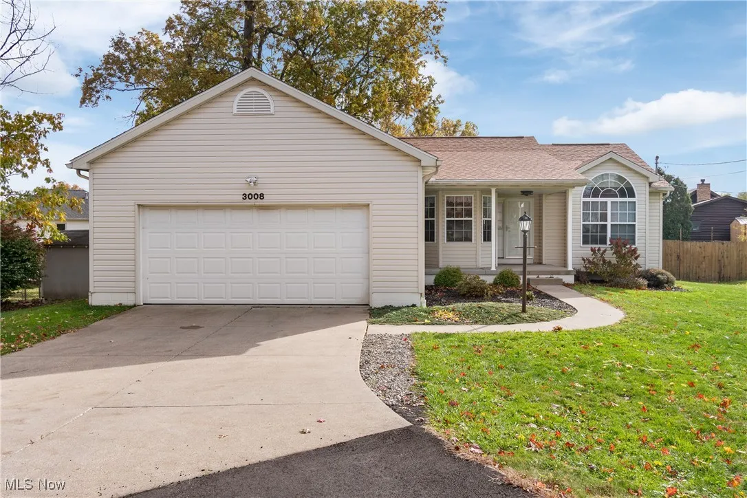 Single story home with driveway, covered porch, an attached garage, and a shingled roof