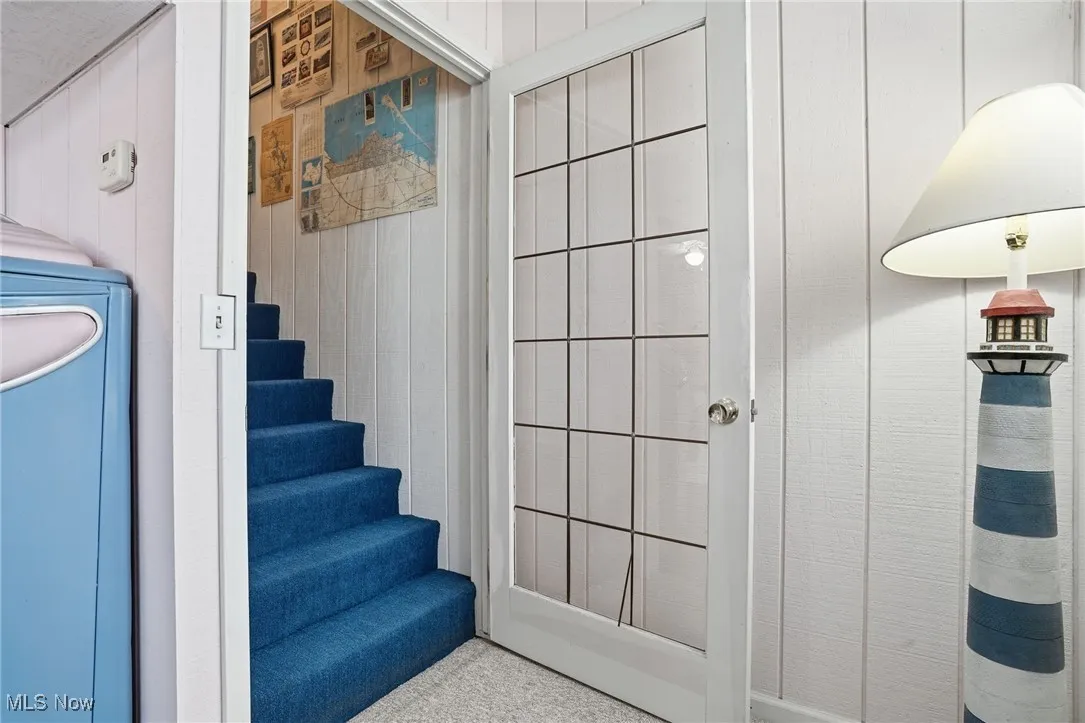Staircase featuring wooden walls