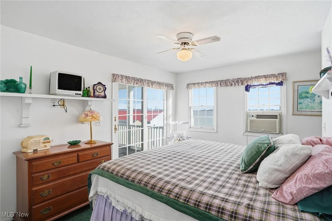Bedroom featuring access to outside, ceiling fan, dark carpet, and cooling unit