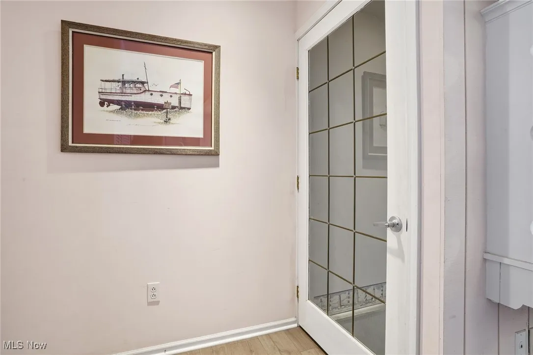 Doorway featuring baseboards and wood finished floors