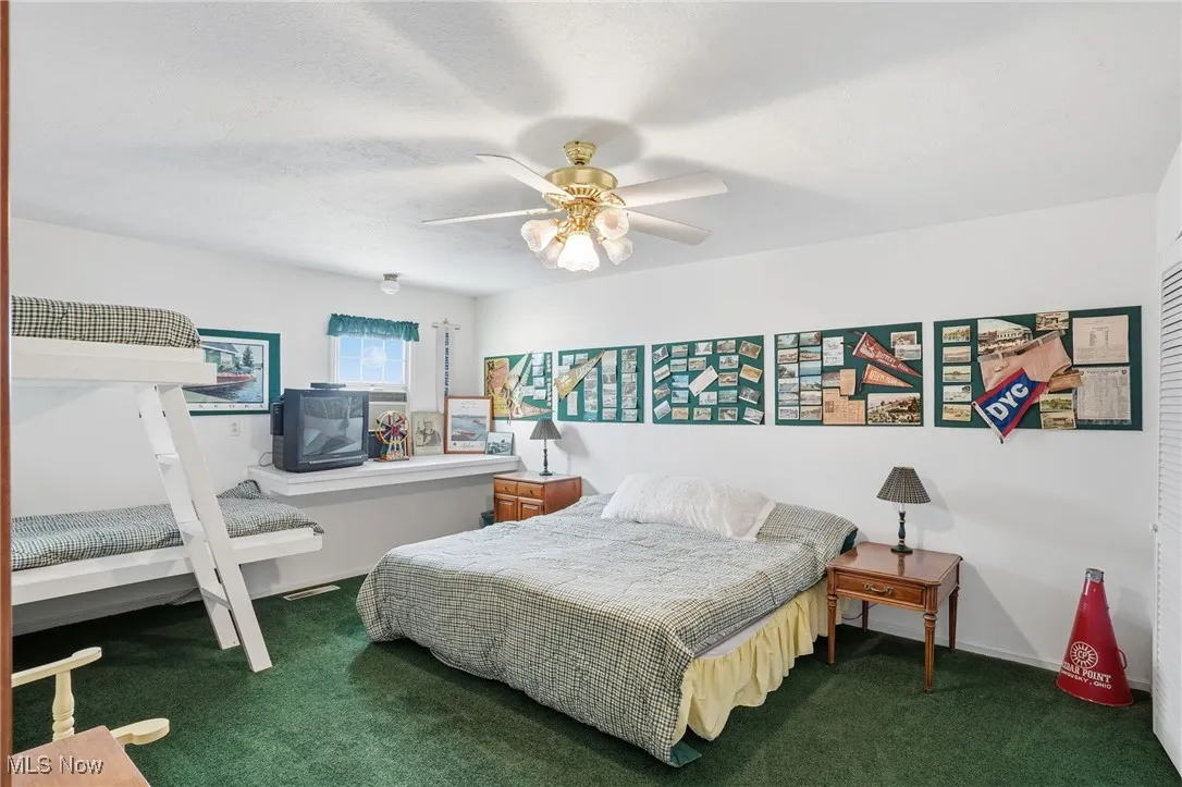 Carpeted bedroom featuring ceiling fan