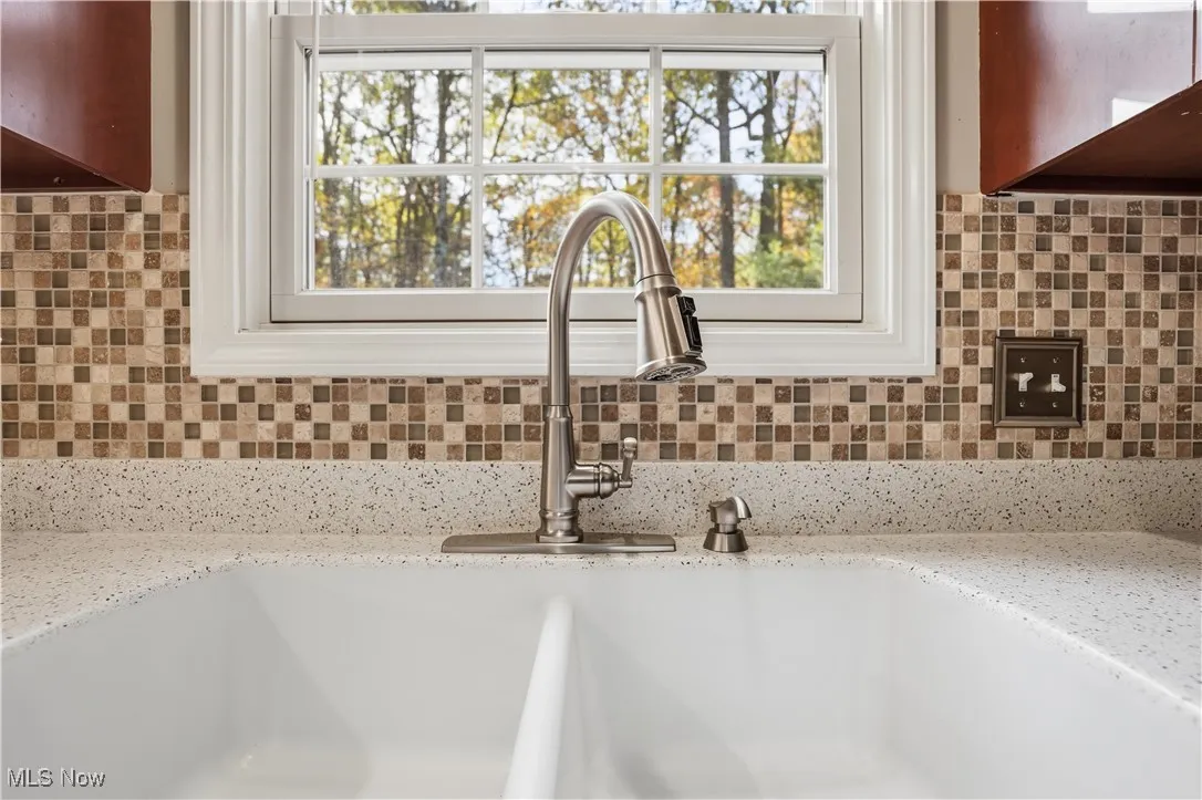 Kitchen view of light stone countertops and decorative backsplash