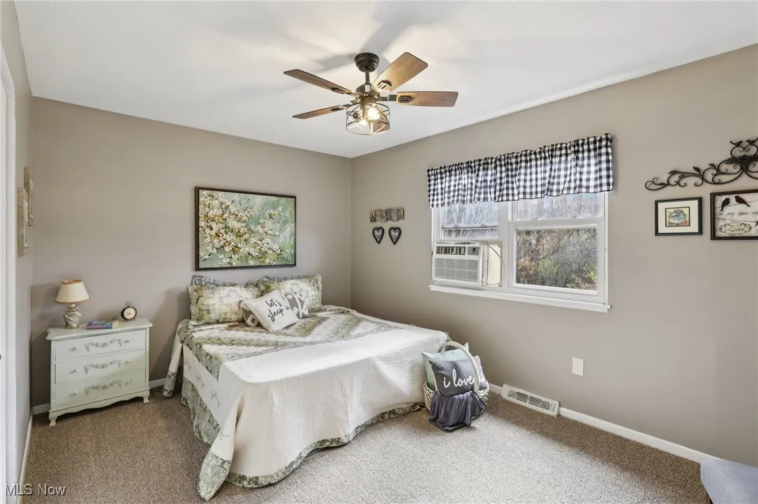 Bedroom with carpet, cooling unit, and ceiling fan