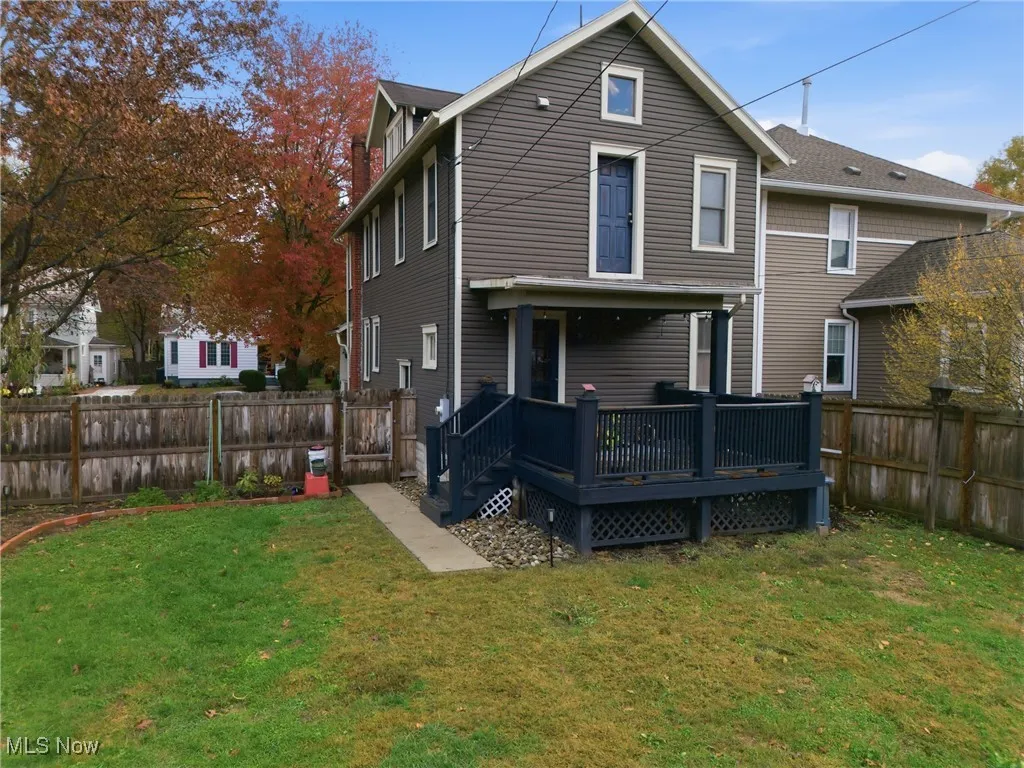 Rear view of house featuring a fenced backyard and a deck