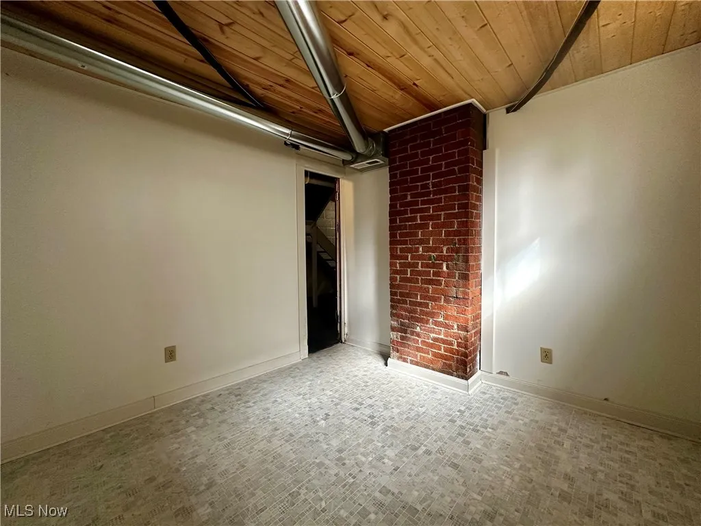 Unfurnished room with wood ceiling and tile patterned floors
