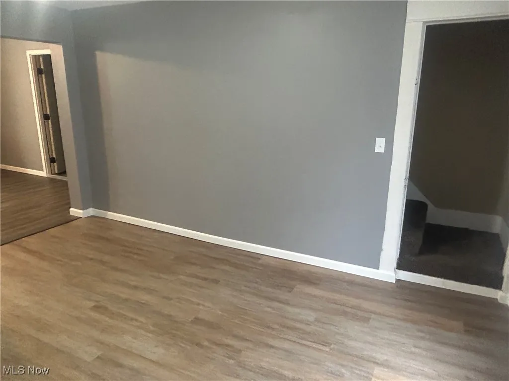 Empty room featuring wood finished floors and baseboards