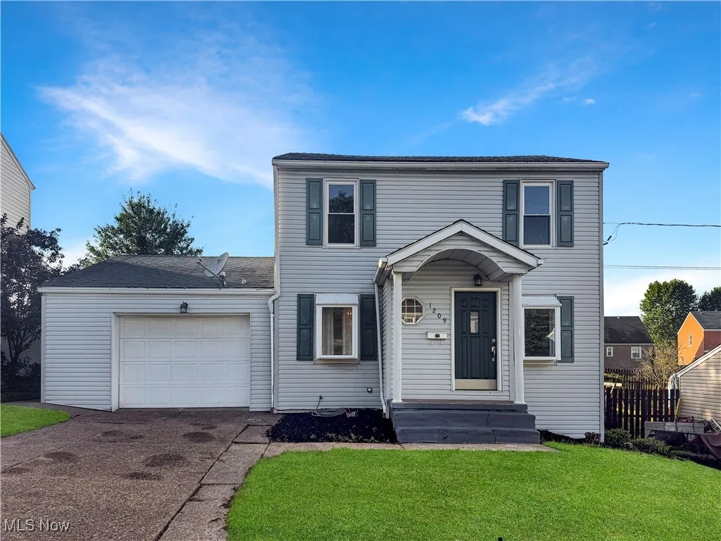 View of front of house with a garage, driveway, and a shingled roof