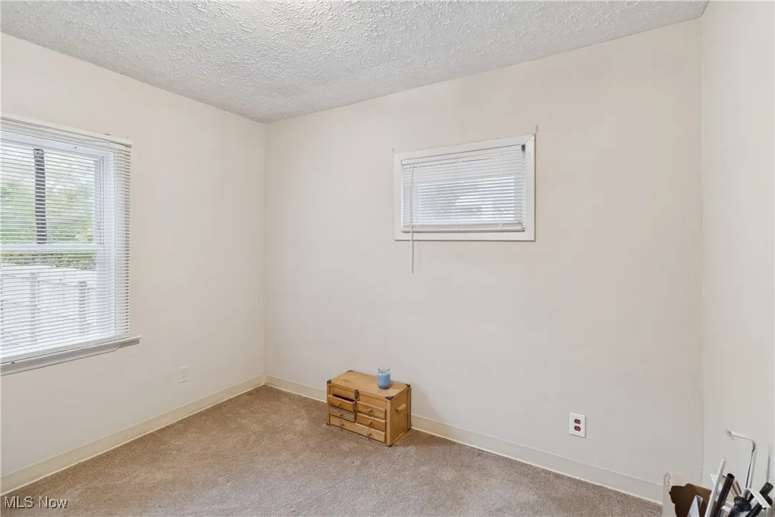 Spare room with a textured ceiling and carpet flooring
