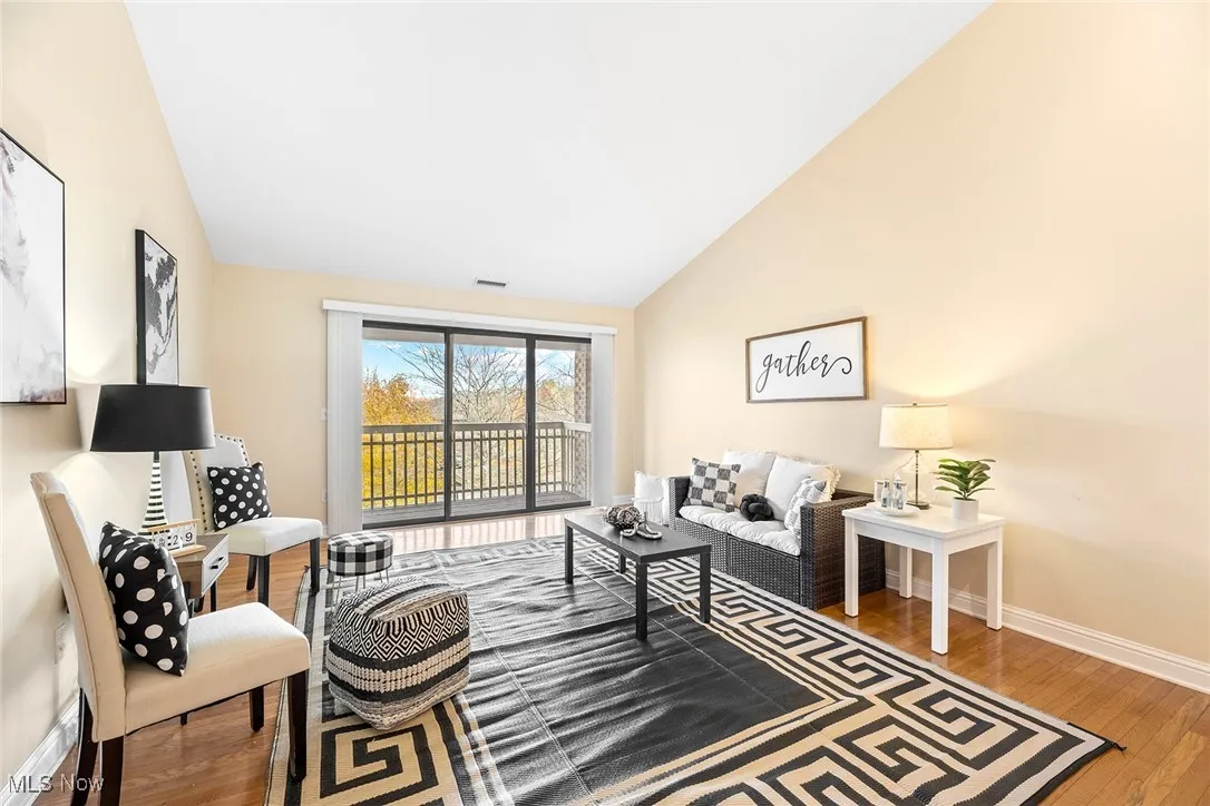 Living room with wood finished floors and vaulted ceiling
