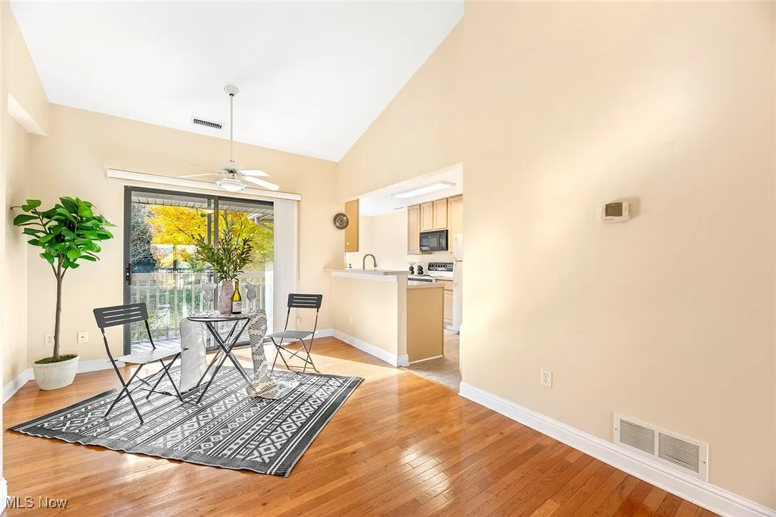 Dining space featuring light wood finished floors, high vaulted ceiling, and ceiling fan