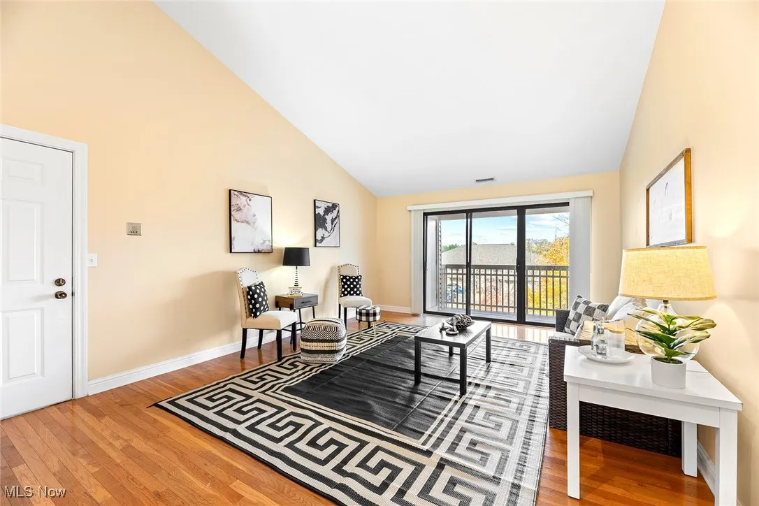 Living area with light wood-type flooring and high vaulted ceiling