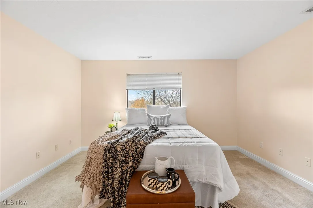 Bedroom with light carpet and baseboards