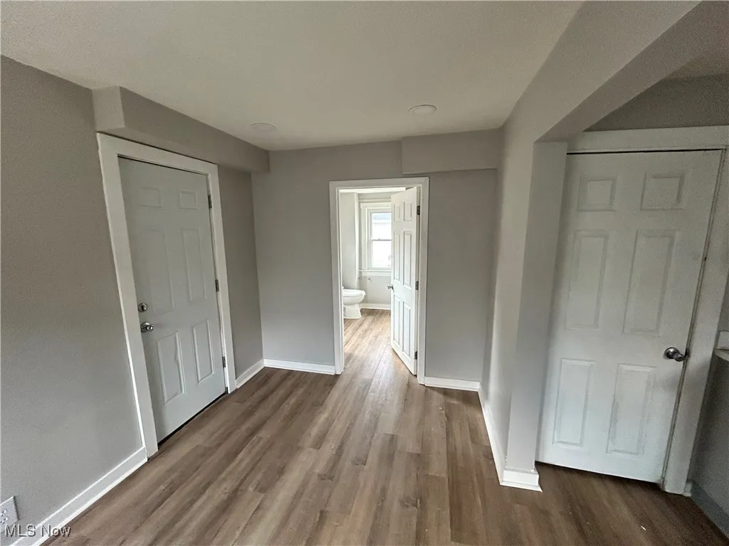 Hallway featuring baseboards and dark wood finished floors