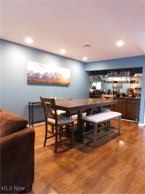 Family room and Dining space with light wood-style floors and recessed lighting