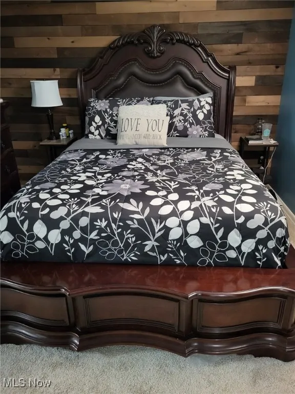 Carpeted bedroom with wood walls