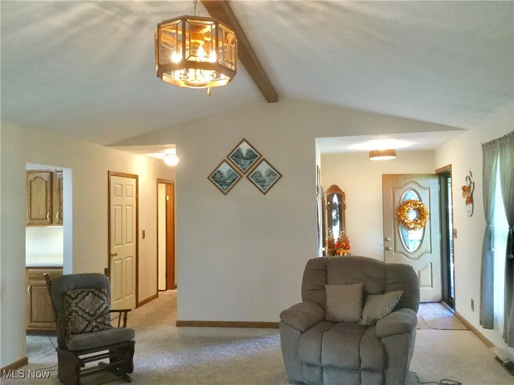 Living area featuring light carpet and a chandelier