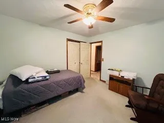 Bedroom 1 with carpet flooring, ceiling fan, and a closet