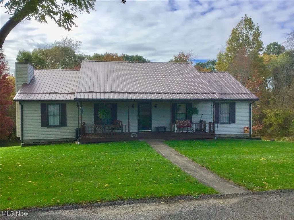 Ranch-style house with a metal roof, covered front porch