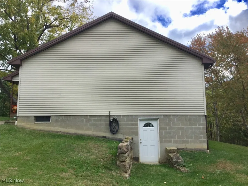 View of side of property with a lawn
