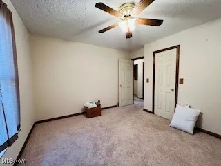 bedroom 2 with a textured ceiling, carpet flooring, and a ceiling fan