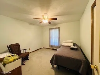 Bedroom 1 featuring light colored carpet and a ceiling fan