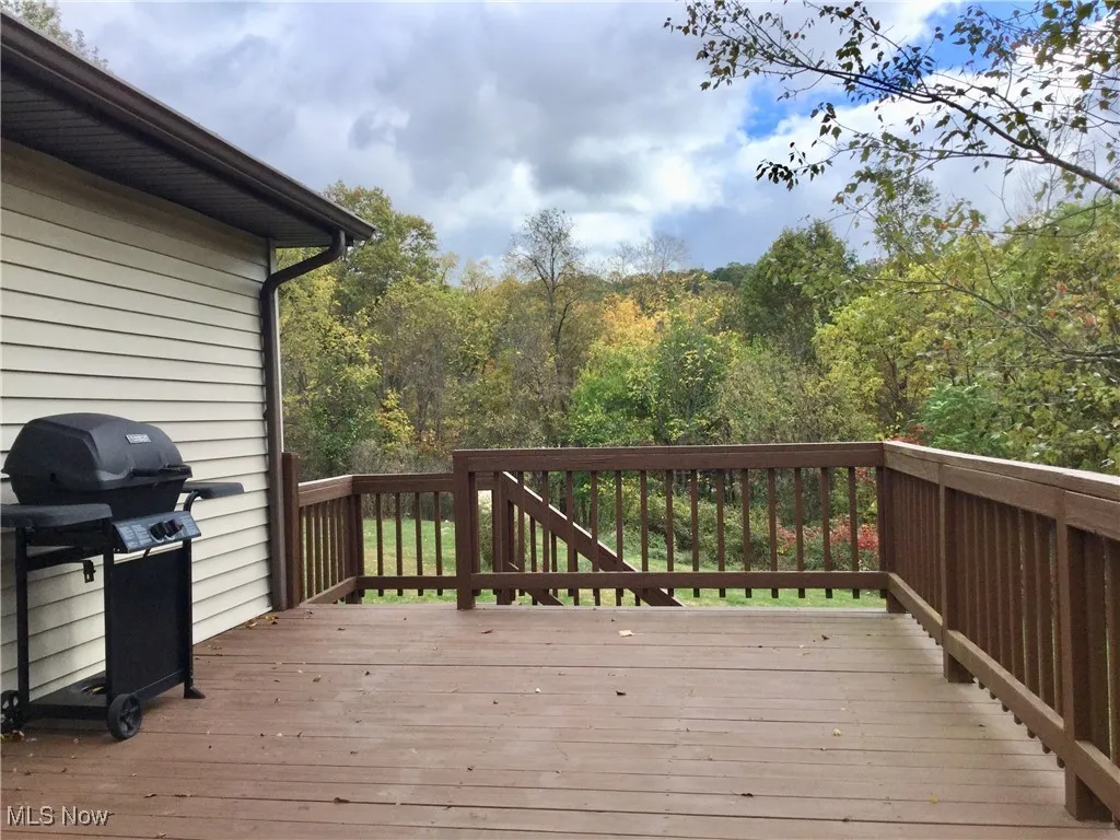 Wooden deck featuring area for grilling