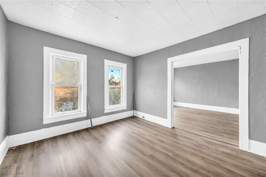 Spare room featuring a textured wall and wood finished floors