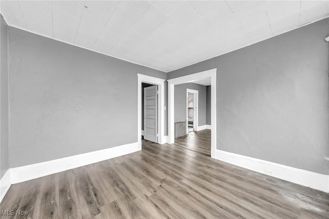 Empty room with a textured wall and wood finished floors