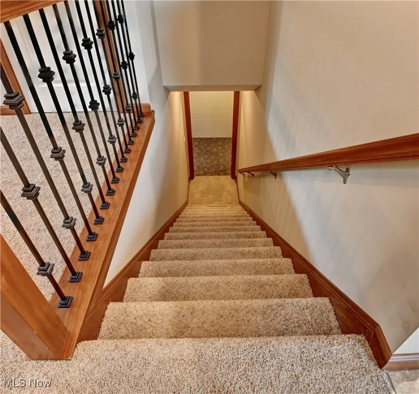 Stairway featuring baseboards and carpet floors