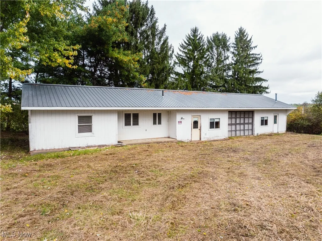 Rear view of house featuring a metal roof and a​​‌​​​​‌​​‌‌​‌‌​​​‌‌​‌​‌​‌​​​‌​​ yard