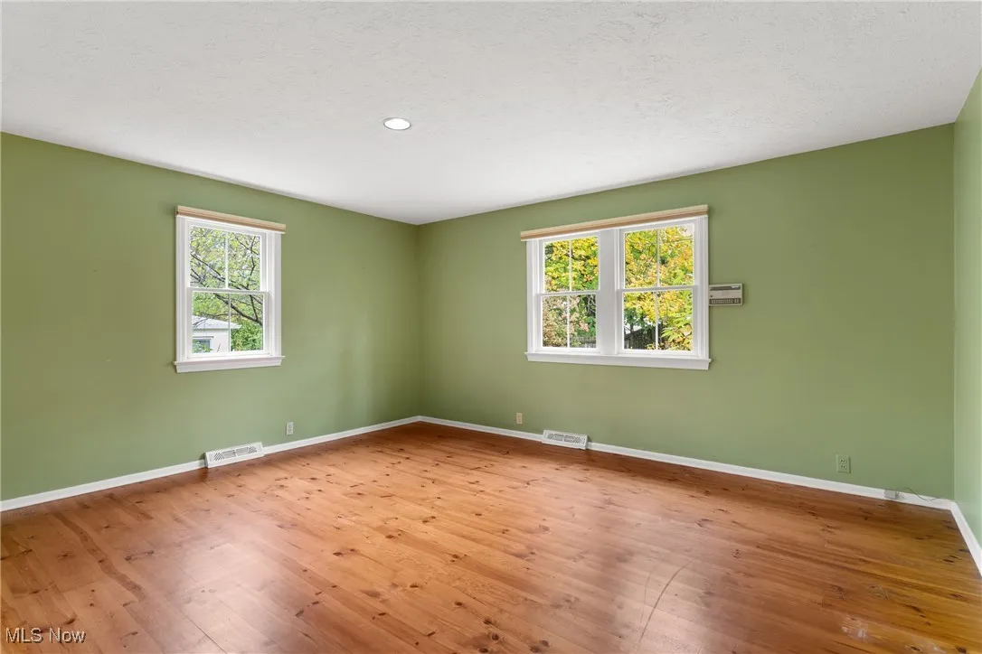 Unfurnished room featuring hardwood / wood-style floors, a textured ceiling, and recessed lighting