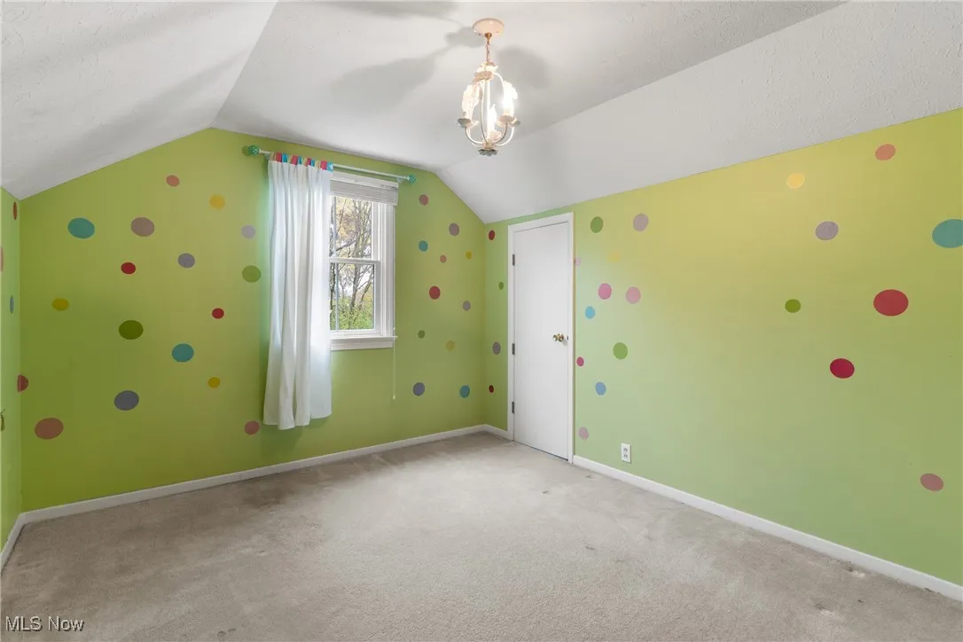 Additional living space featuring carpet and lofted ceiling