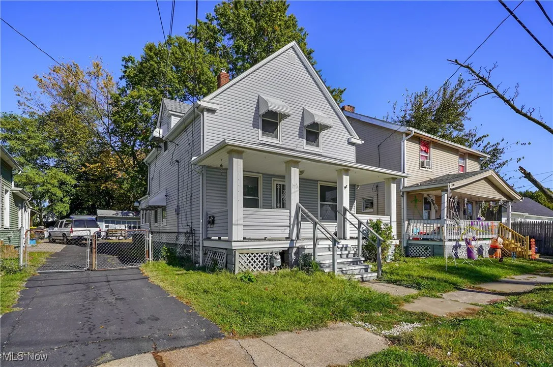 View of front of property with covered porch, a chimney, and a gate