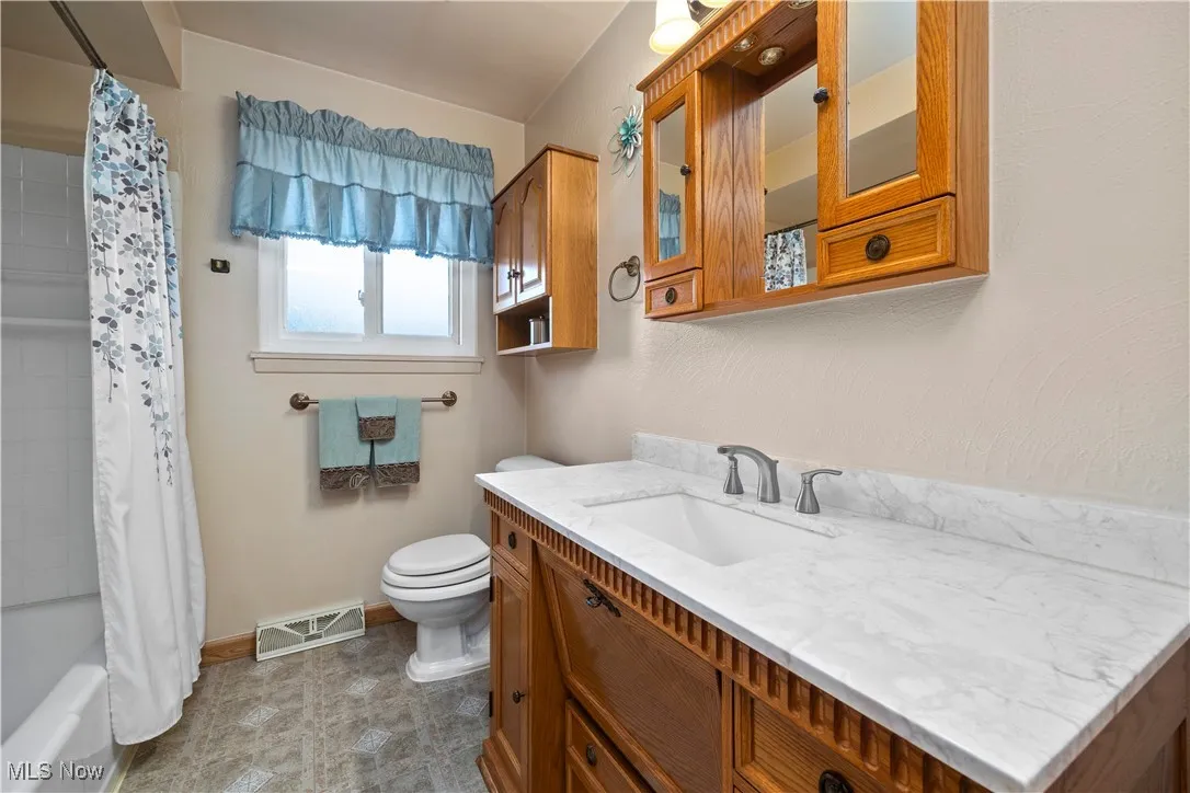 Full bath featuring shower / tub combo and vanity