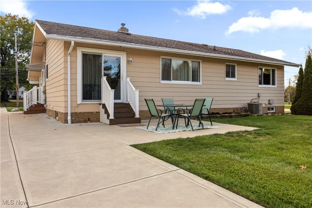 Rear view of property featuring a patio, a chimney, crawl space, entry steps, and a yard