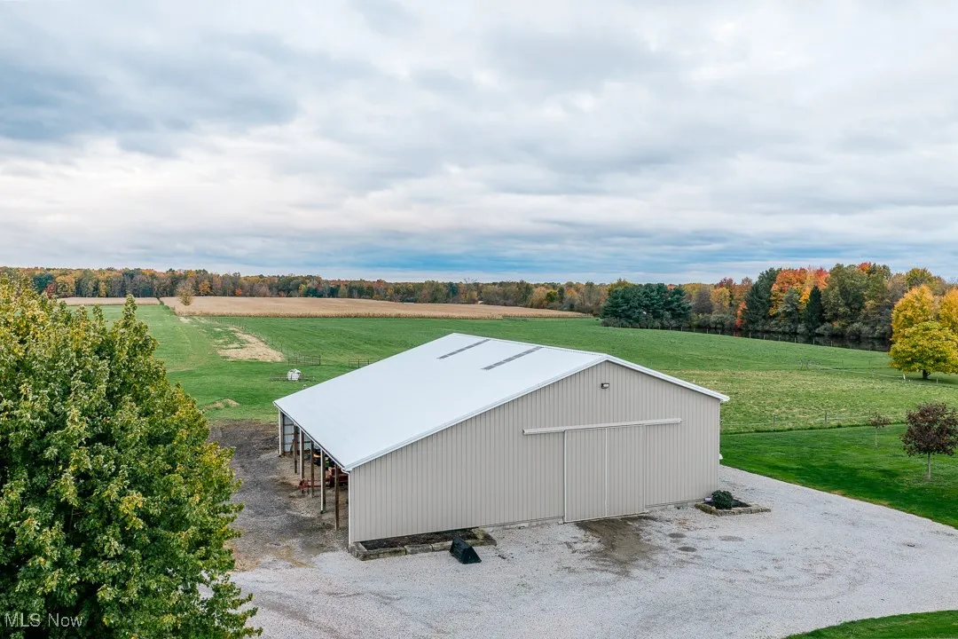 View of pole building featuring a lawn and a view of countryside