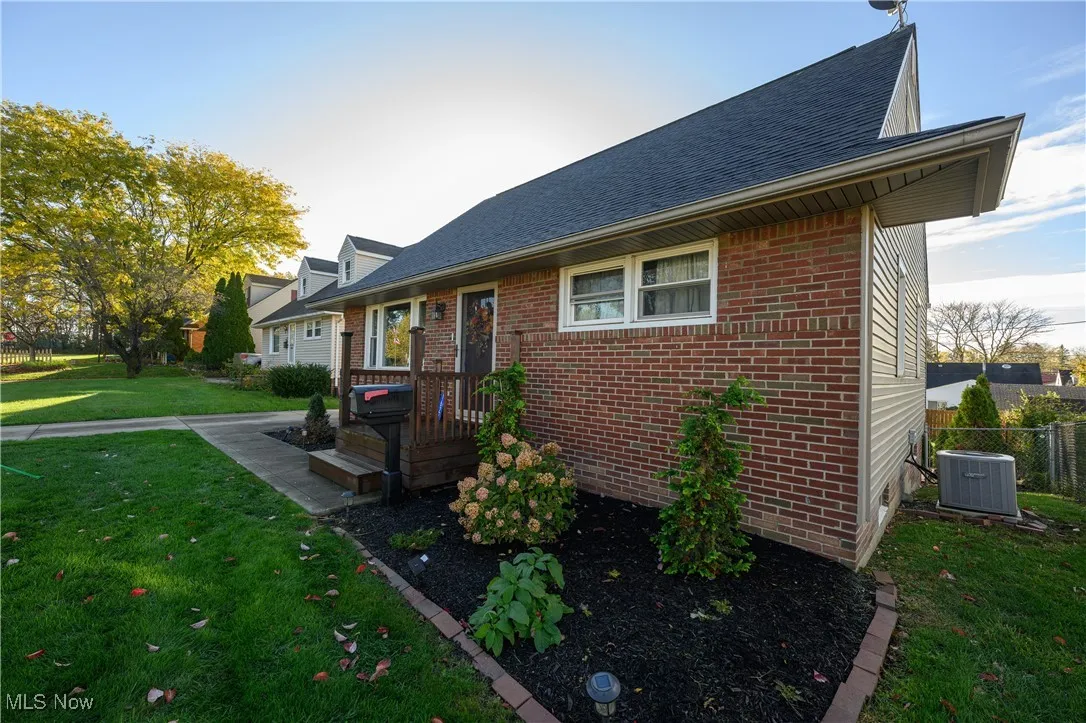 View of front of house with brick siding, roof with shingles, and a deck