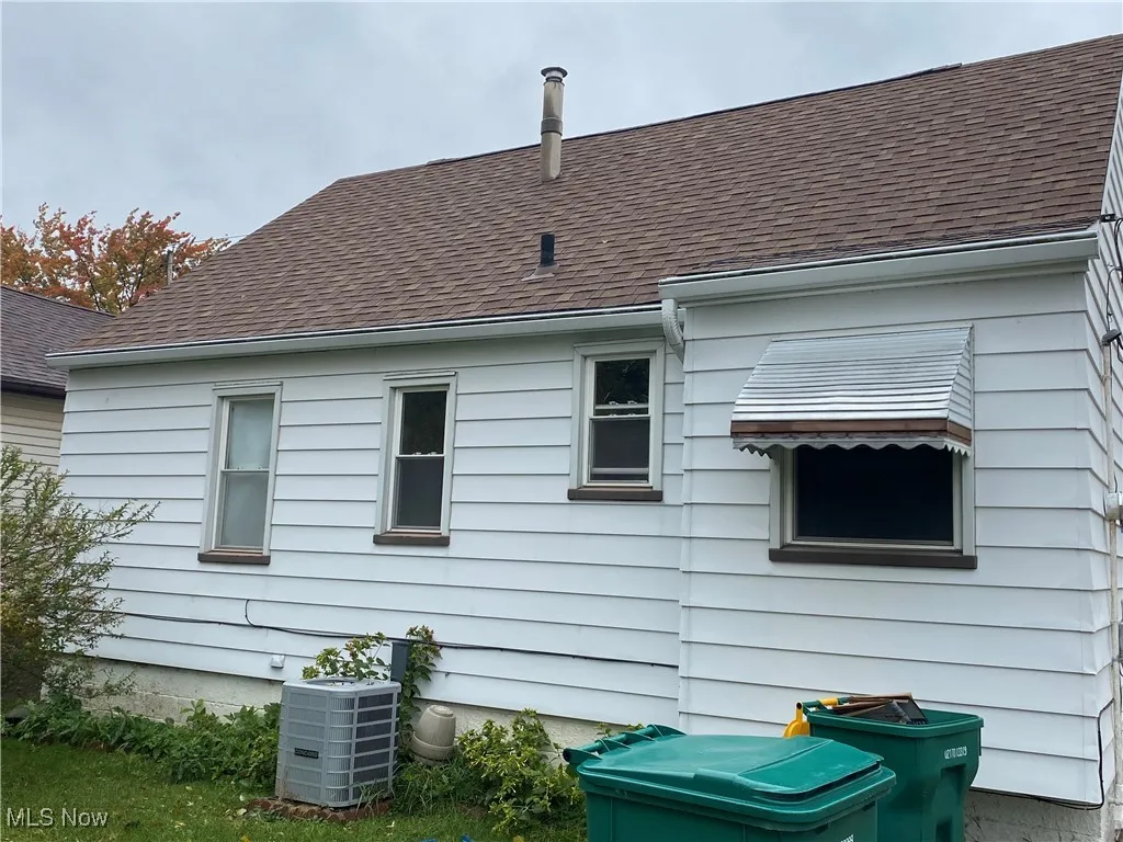 View of side of property featuring roof with shingles