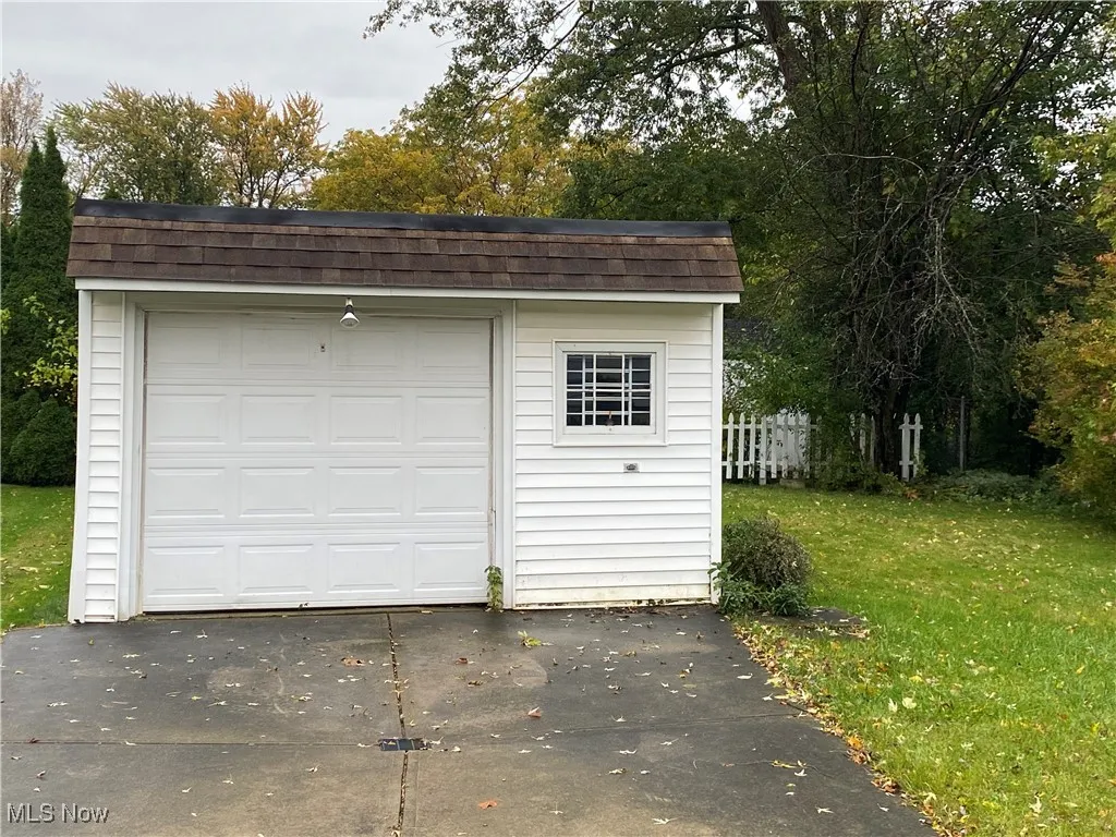 Detached garage featuring concrete driveway