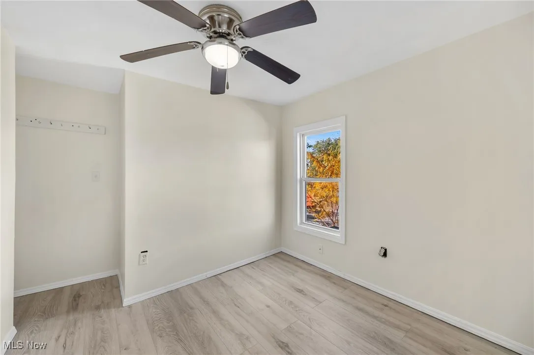 Empty room with light wood-style flooring and ceiling fan