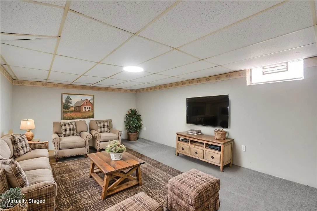 Living area with carpet and a paneled ceiling