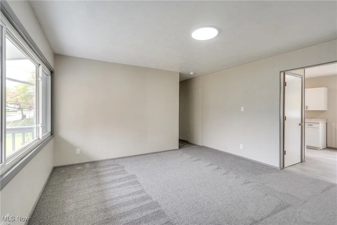 Spare room featuring light carpet and baseboards