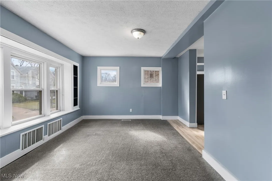 Spare room featuring a textured ceiling and light carpet