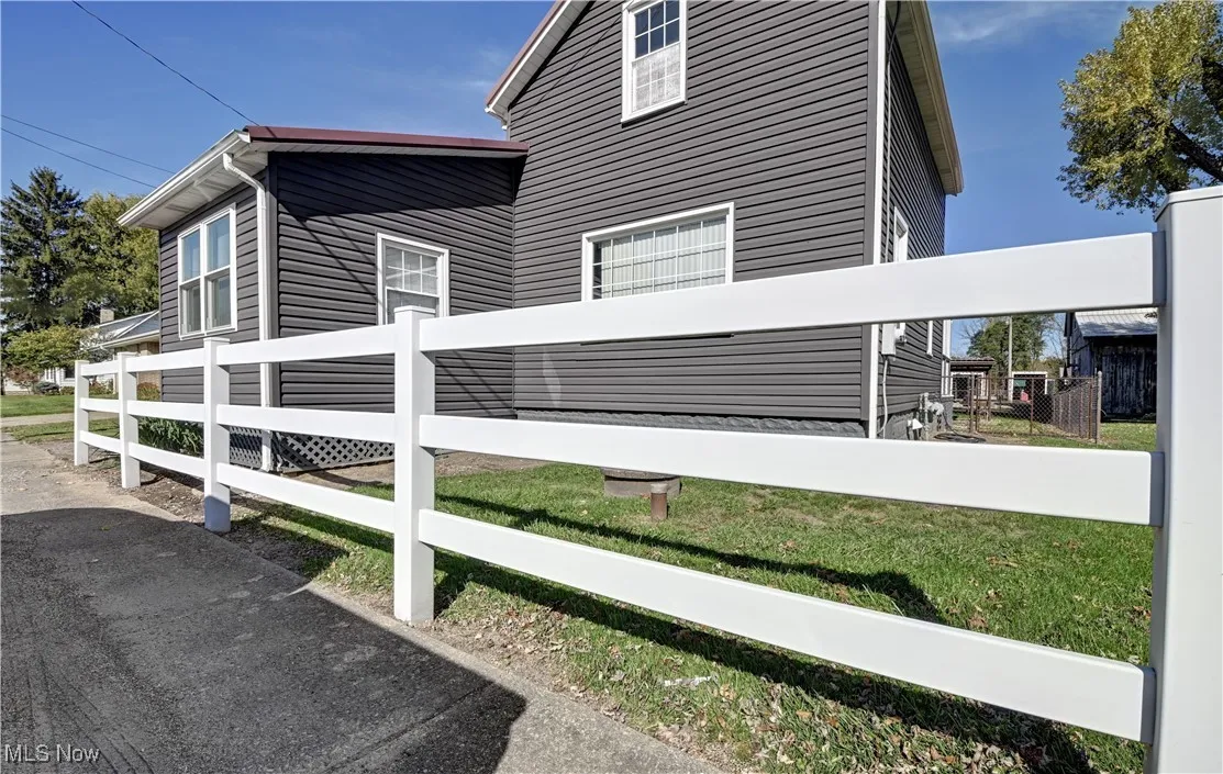 View of property exterior featuring a fenced front yard