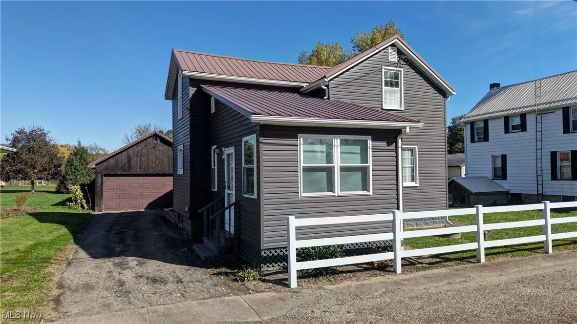 View of front of home featuring an outdoor structure and a metal roof