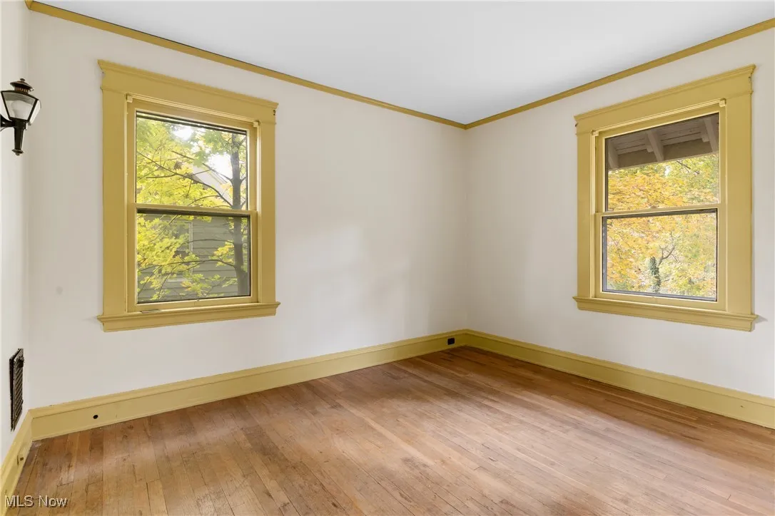 Spare room featuring light wood-style flooring and crown molding