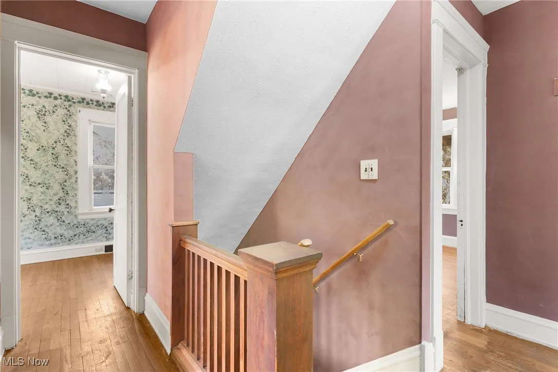 Staircase featuring hardwood / wood-style flooring and baseboards